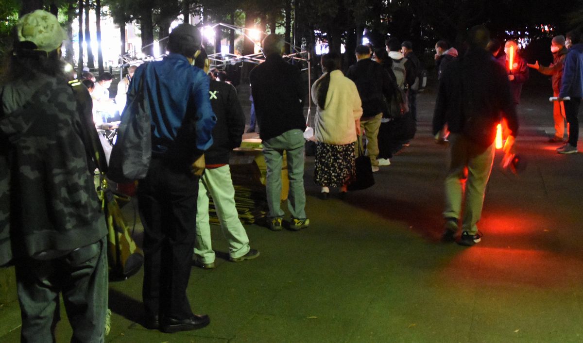 写真・図版 : 東京都豊島区と生活困窮者支援団体の「世界の医療団」、「TENOHASI」が連携し、路上生活者が対象の新型コロナウイルスのワクチン接種を実施した。受付会場の公園に長い列ができた＝2021年10月30日