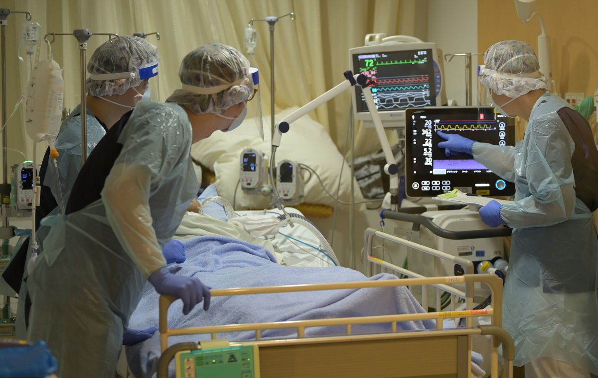 写真・図版 : 都立駒込病院で人工呼吸器をつけた新型コロナの重症患者を診る医師ら＝2021年9月