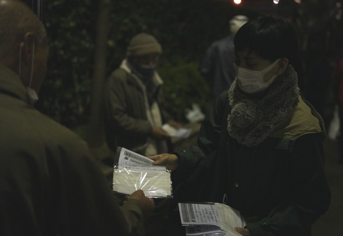 写真・図版 : 路上生活者らにマスクを配る支援団体＝2020年4月、東京都豊島区