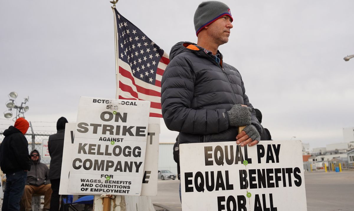 写真・図版 : 激しい物価上昇を契機に賃金改善などを求めてストライキに入った工場の従業員ら＝2021年11月、米ネブラスカ州
