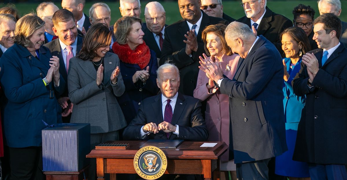 写真・図版 : ホワイトハウスでインフラ投資法に署名するバイデン大統領（中央）＝2021年11月15日、ワシントン