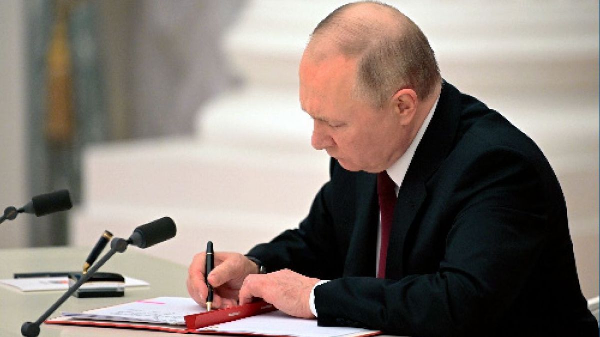 写真・図版 : ウクライナ東部の「ドネツク人民共和国」と「ルガンスク人民共和国」の独立を承認する書類に署名するロシアのプーチン大統領。ロシア大統領府が写真を公表した＝2022年2月21日、モスクワ