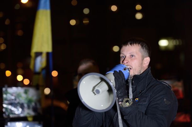 写真・図版 : キエフの選挙区の街頭小集会で戦場のパネルを立て、支持者に語りかけるビレツキー・アゾフ連隊司令官＝2014年10月21日