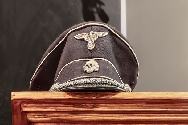 写真・図版 : トーテムコップ（ドクロのマーク）があしらわれたナチス親衛隊の制帽＝2018年6月3日、ポーランド・クラクフの博物館、agsaz/shutterstock.com