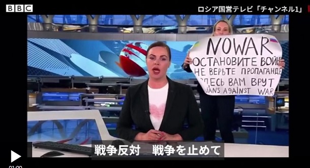 「NO WAR」のプラカードを掲げたマリーナ・オフシャニコワさん(右)＝BBC NEWS JPANより