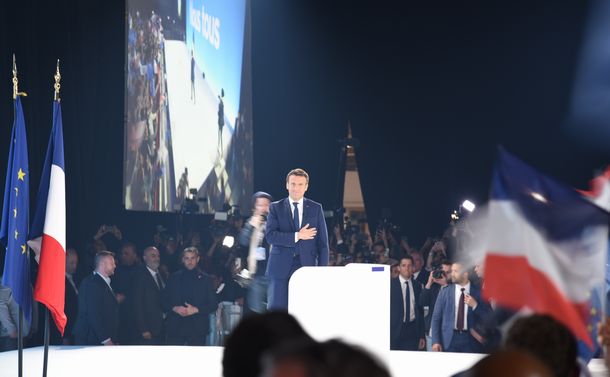 写真・図版 : パリで10日、大統領選の1回目投票で首位に立ち、支持者の前に姿を見せたマクロン大統領（中央）＝2022年4月11日、パリ
