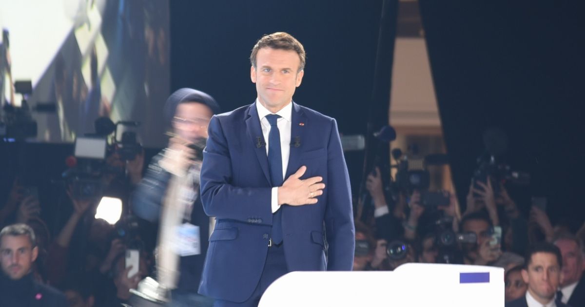 写真・図版 : パリで10日、大統領選の1回目投票で首位に立ち、支持者の前に姿を見せたマクロン大統領（中央）＝2022年4月11日、パリ