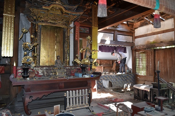 写真・図版 : 荒れ果てた金皇寺の本堂。奥で位牌などを片づけているのは浄土宗の職員＝2020年8月、島根県大田市