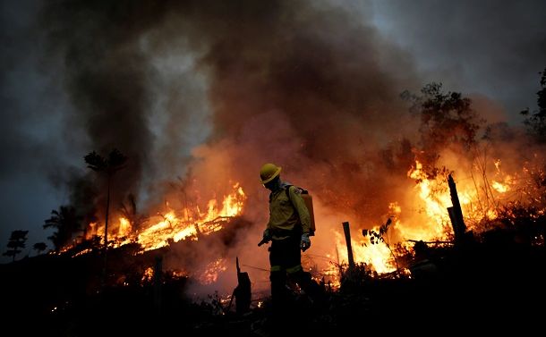 写真・図版 : ブラジル・アマゾナス州の森林火災で消火活動にあたる消防隊員＝2020年8月、ロイター