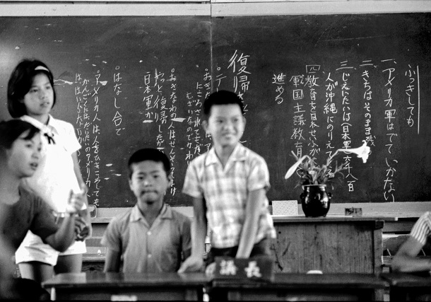 写真・図版 : 復帰当日、沖縄県豊見城村(現・豊見城市)の上田小学校で開かれた復帰を考える討論会。「アメリカ軍はでていかない」「きちはそのまま残る」と黒板に書かれている=1972年5月15日

