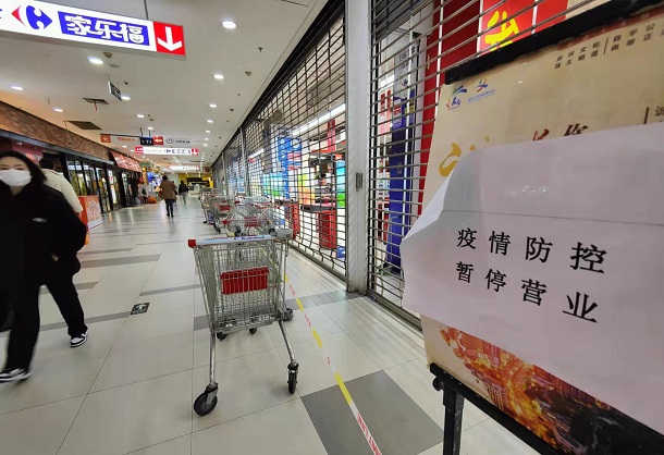 「コロナ対策でしばらく営業停止」との紙が貼り出されたスーパー＝２０２２年３月３０日、上海市