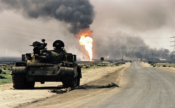 写真・図版 : 黒煙を上げて燃えるクウェート南部の油田。手前に見えるのは放置されたイラク軍の戦車。湾岸戦争ではこういった情景が各国メディアを通じて届けられた＝1991年4月