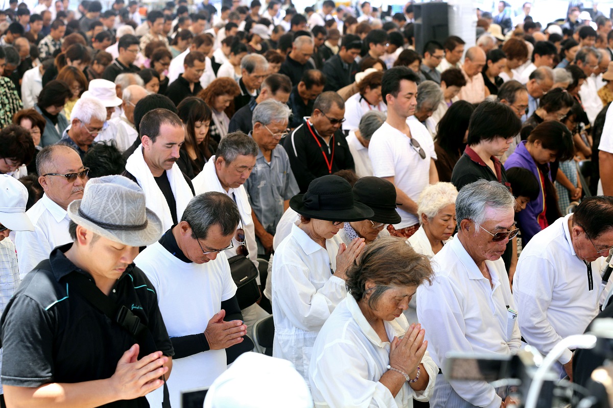 写真・図版 : 沖縄全戦没者追悼式で、手を合わせる人たち＝2013年6月23日、沖縄県糸満市の平和祈念公園