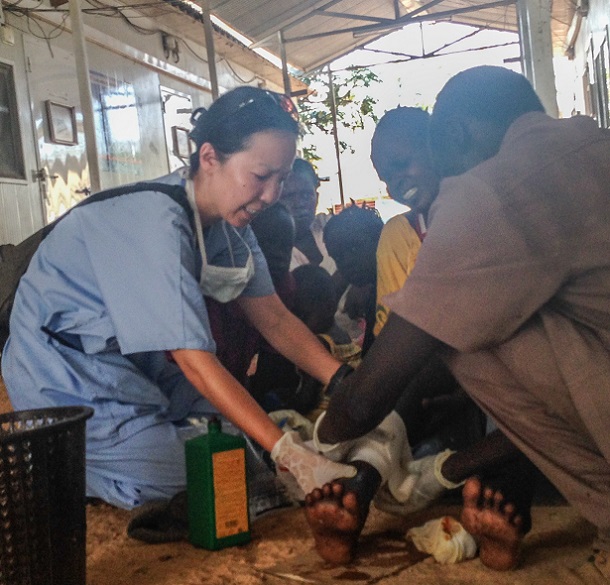 写真・図版 : 南スーダン・マラカルで戦闘に巻き込まれて負傷した住民の手当てをする白川さん＝2014年3月、国境なき医師団提供 