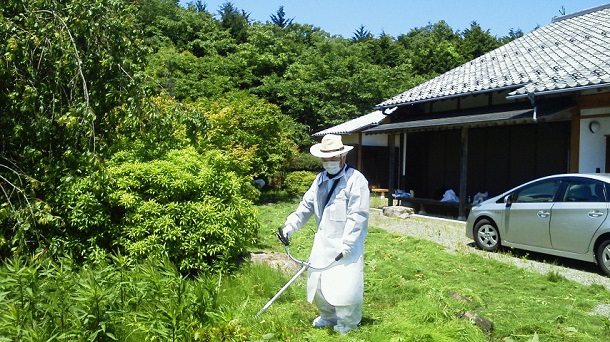 帰還困難区域にある自宅に一時帰宅した際、庭の除草作業をする住民＝2018年5月20日、福島県富岡町