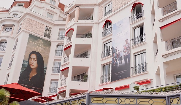 写真・図版 : カンヌの高級ホテル「マジェスティック」には『ベイビー・ブローカー』(右)とパク・チャヌク監督『別れる決心』の2本の韓国映画のポスターが並んだ=撮影・林瑞絵