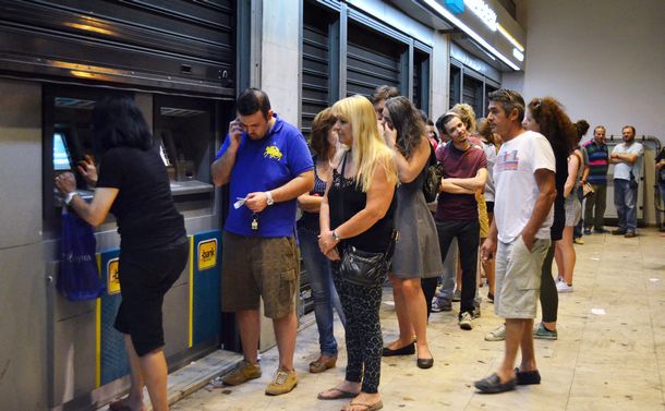 写真・図版 : ギリシャ危機でユーロ離脱が噂され、預金を引き出すためにATMの前で行列をつくる人たち＝2015年6月、アテネ 