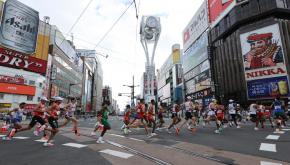 写真・図版 : 東京五輪の男子マラソン。札幌・すすきの交差点を駆け抜ける選手たち＝2021年8月8日
