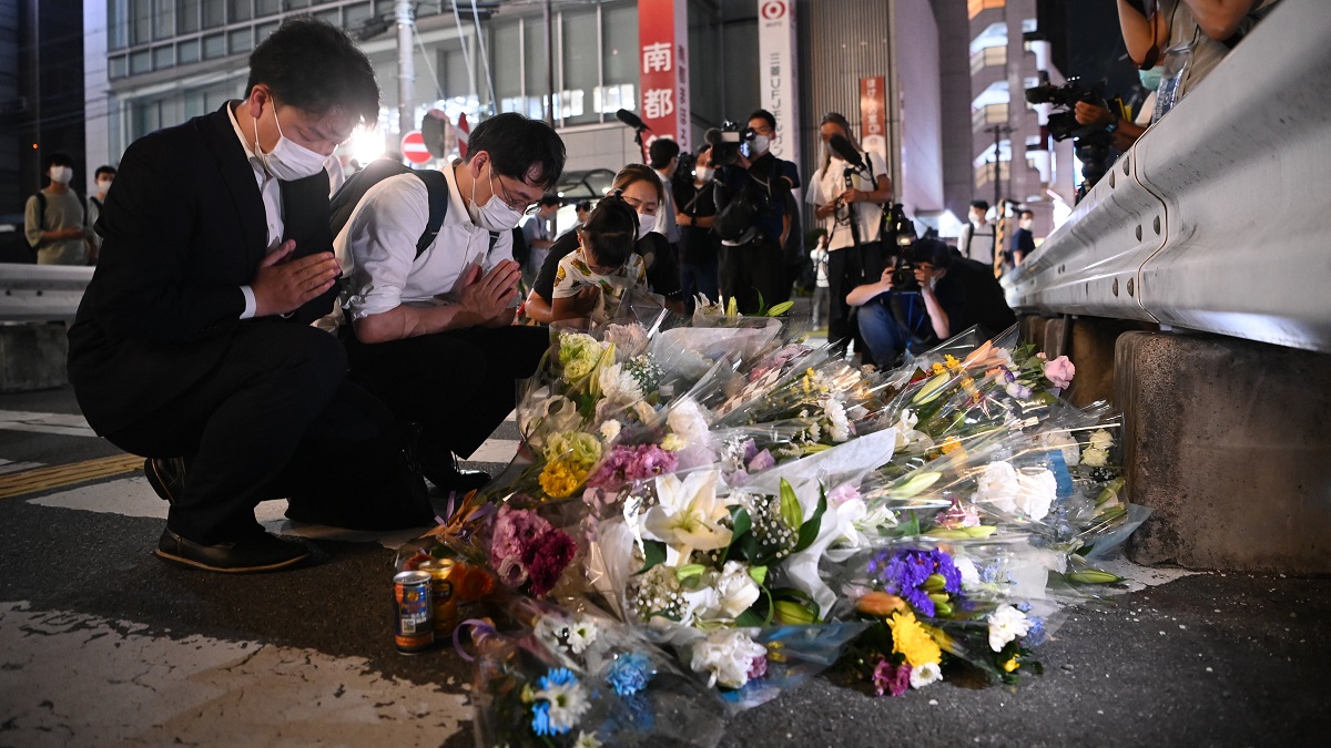 写真・図版 : 安倍晋三元首相が撃たれた現場で手を合わせる人たち＝2022年7月8日、奈良市