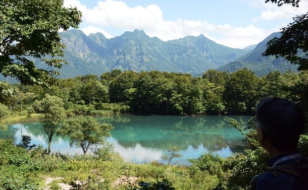 糸魚川ジオパークにある「白池」。水面に山並みが映る＝新潟県糸魚川市