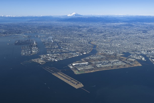 写真・図版 : 川崎臨海部を東京湾から望む。手前の羽田空港から多摩川を越えた白い建物群（写真中央）が「キングスカイフロント」＝川崎市提供