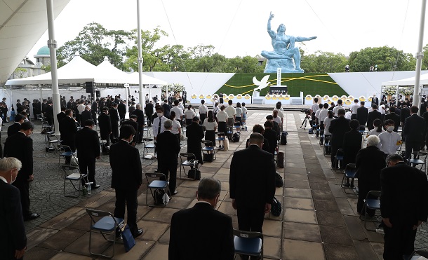 写真・図版 : 長崎原爆犠牲者慰霊平和祈念式典で黙祷する参列者＝2021年8月9日、長崎市の平和公園、代表撮影
