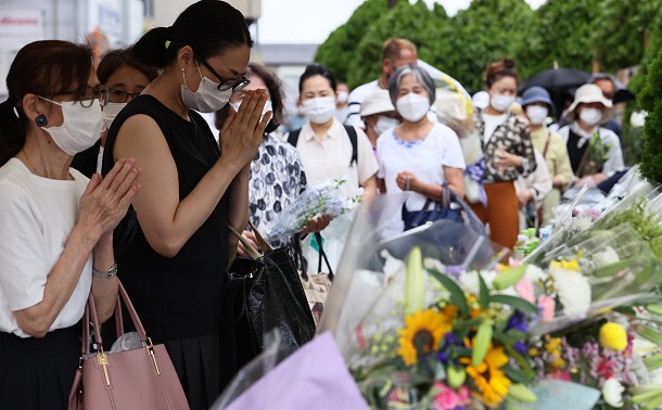 写真・図版 : 安倍晋三元首相が銃撃された現場近くの献花台で＝2022年7月11日、奈良市