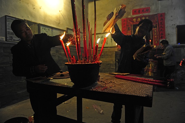 土楼の中心部にある祖堂に集まり、大きな蠟燭に火を灯す承継楼の住民たち。2016年