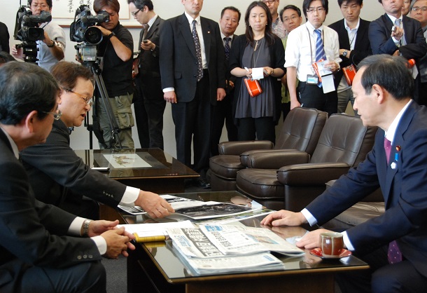 2013年4月3日、菅官房長官(当時、右)は琉球新報社と沖縄タイムス社を訪問した。写真は米軍機による事故について説明する沖縄タイムスの武富和彦編集局長(左手前2人目)