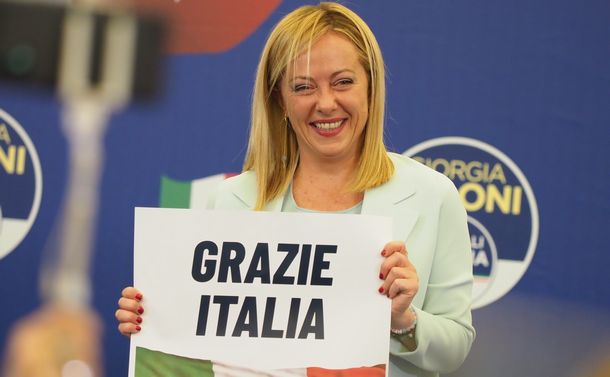 写真・図版 : 総選挙で第1党に躍進する見通しとなり、「ありがとう　イタリア」と書かれたカードを持って喜びを表すジョルジャ・メローニ党首＝2022年9月26日、ローマ