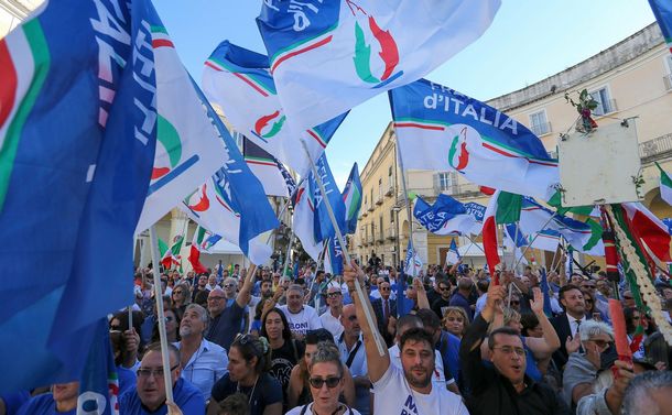 写真・図版 : 総選挙で「イタリアの同胞」の旗を振る支持者ら＝2022年9月18日、イタリア・カゼルタ