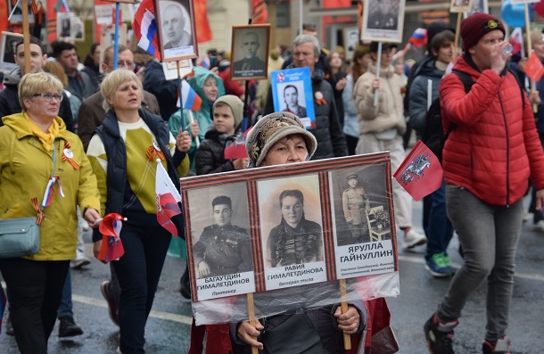 第2次世界大戦を経験した親族の写真を掲げて歩く市民=9日、モスクワ202205


