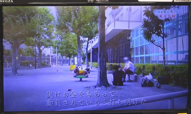 写真・図版 : BS1スペシャル「河瀬直美が見つめた東京五輪」の一場面。「実はお金をもらって動員されていると打ち明けた」と字幕を入れて男性を紹介している＝NHK・BS1の放送から