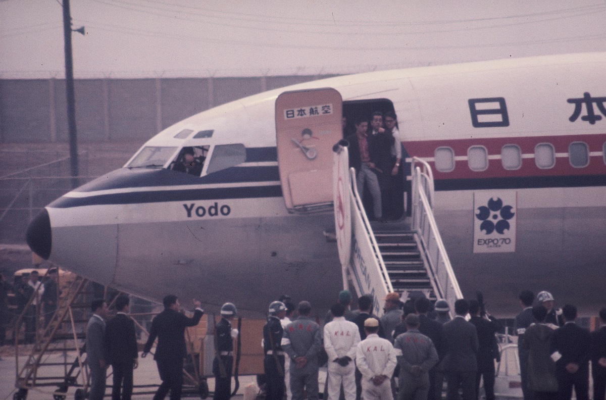 韓国・金浦空港でよど号から乗客を降ろすとき姿を見せた赤軍派。タラップの上で短刀を手にしているのは田中義三（2007年死去）＝1970年4月3日