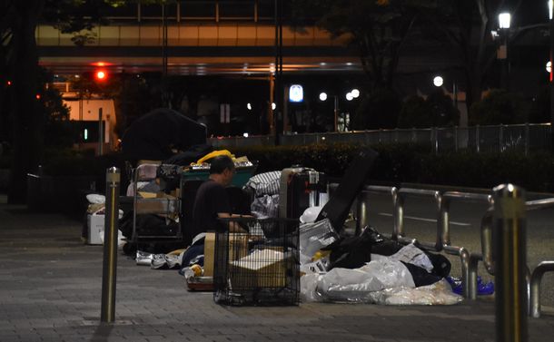写真・図版 : 都庁近くの路上で寝泊まりする人たち＝2021年7月15日、新宿区西新宿2丁目