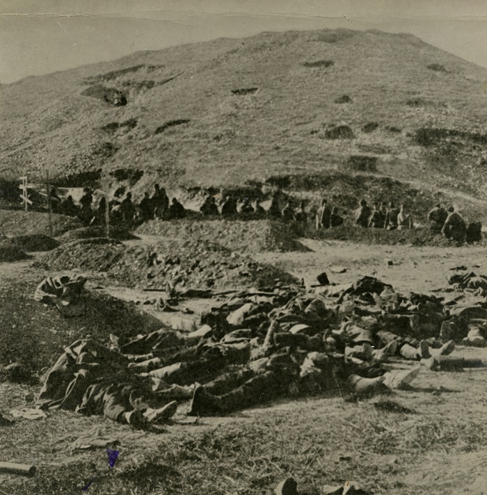 第３次旅順総攻撃で多大な犠牲を払って日本軍が占領した二〇三高地をふもとから見る。手前に並んでいるのは戦死したロシア兵の遺体＝1904年12月5日、中国・遼寧省の旅順近郊 