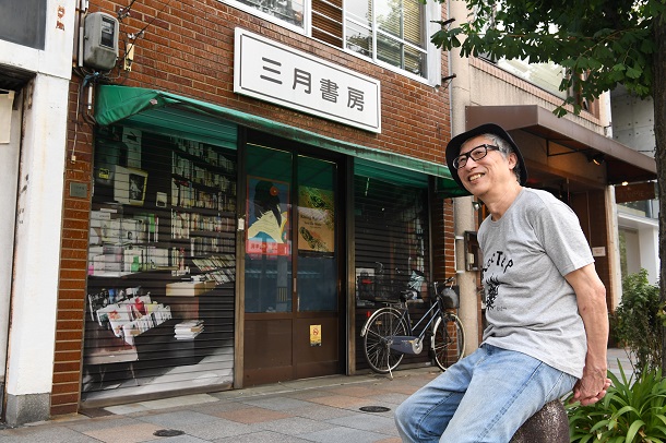 た三月書房の前で笑顔の３代目店主の宍戸立夫さん＝２０２０年８月