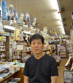 定有堂書店の奈良敏行さん。店内には、奈良さんや店のファンの手作りの「オブジェ」などがつるされている＝鳥取市元町2013年