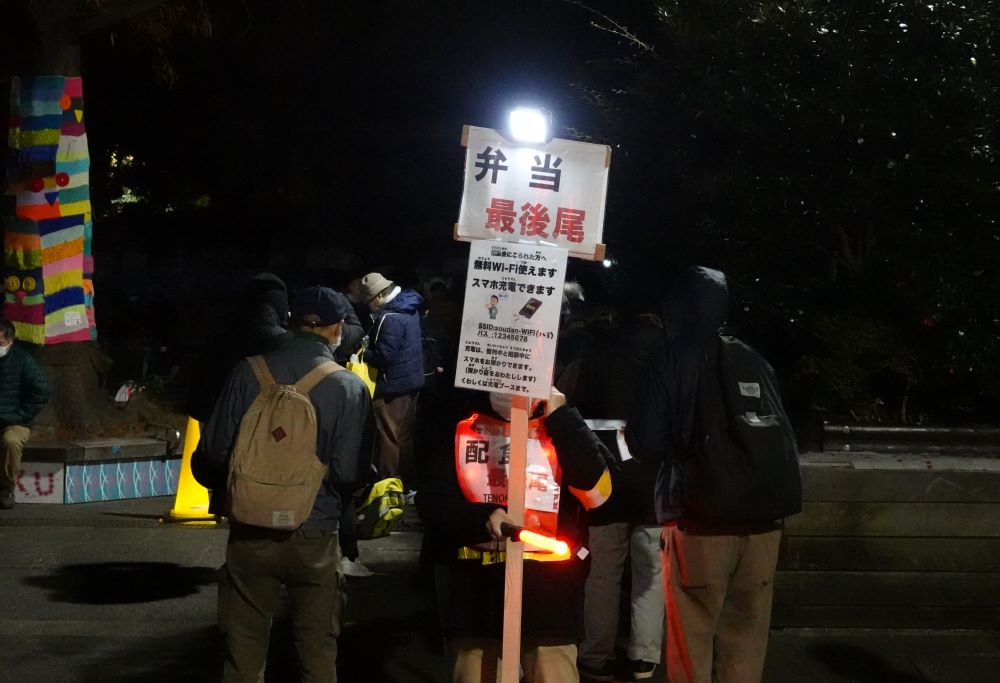 困窮者を支援するＮＰＯ法人「ＴＥＮＯＨＡＳＩ（てのはし）」のスタッフや食品配布を待つ人ら＝２０２２年１２月３１日、東京都豊島区