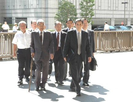 写真・図版 : 東京高裁の庁舎に入る東郷元頭取（手前右）、岩城元副頭取（手前左）ら＝８月３０日午前１０時１分、東京・霞が関で