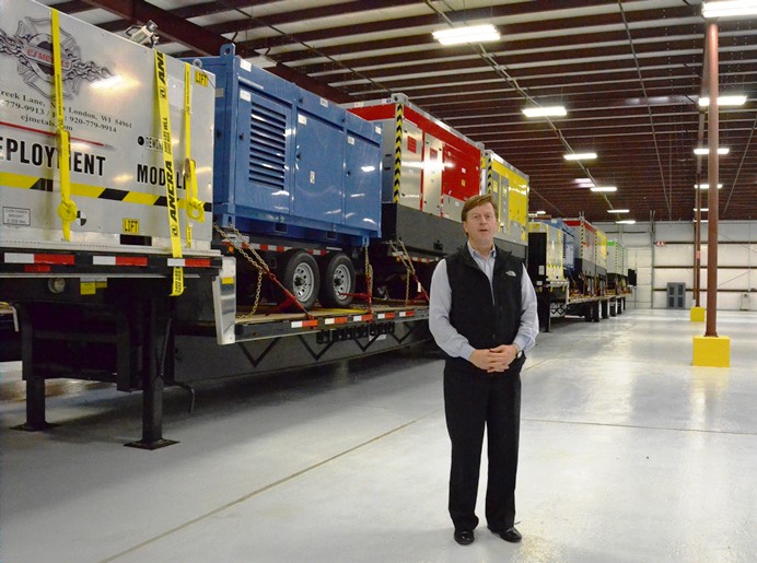 写真・図版 : 米国の原子力業界の緊急事態対応センターの倉庫で機材の前に立つクローリーさん