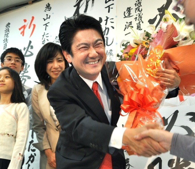 写真・図版 : 花束を受け取り、笑顔をみせる山下貴司さん＝2012年12月16日、岡山市中区
