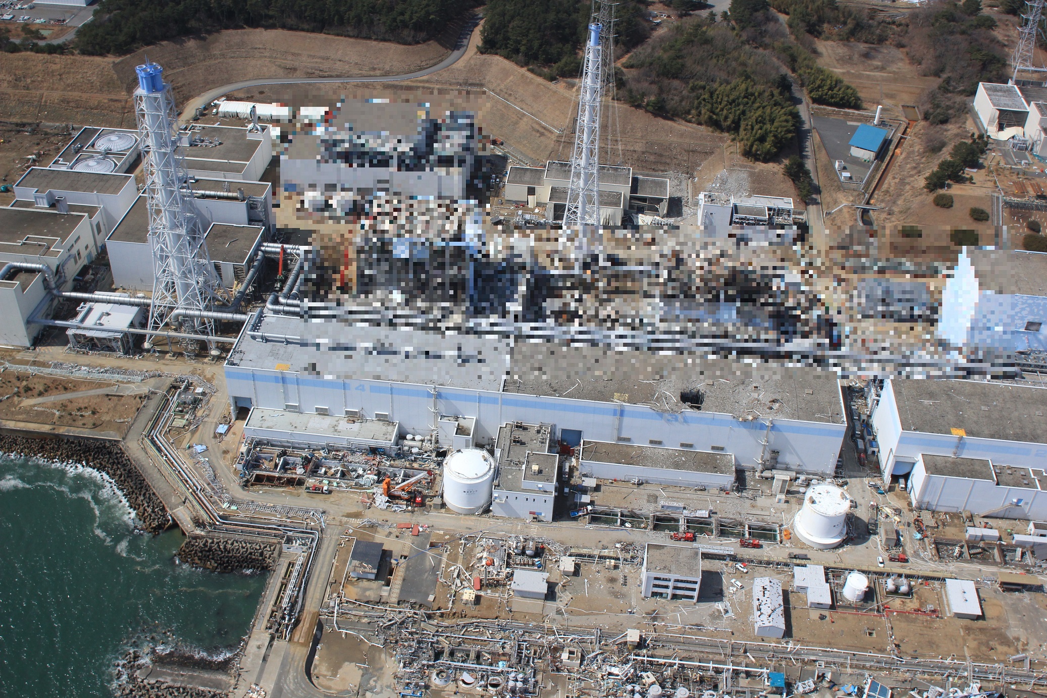 写真・図版 : 福島第一原発４号機（左）、３号機、２号機＝東京電力ホールディングスが2020年12月22日に公表した2011年3月24日撮影の「福島第一原子力発電所事故の状況に係る写真」